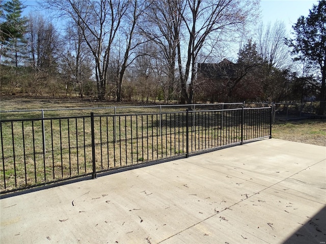 view of patio featuring driveway and fence