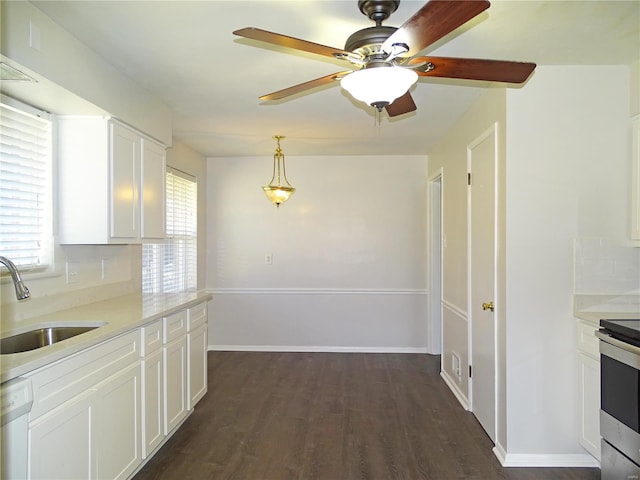 kitchen with dishwasher, light countertops, white cabinetry, and a sink