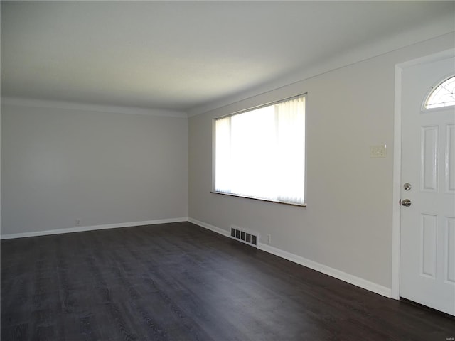 entrance foyer with visible vents, baseboards, dark wood-type flooring, and a healthy amount of sunlight