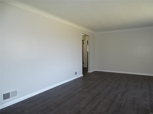 unfurnished room with dark wood-type flooring, baseboards, and visible vents