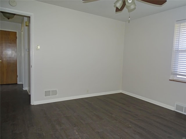 spare room featuring visible vents, plenty of natural light, a ceiling fan, and dark wood-style flooring