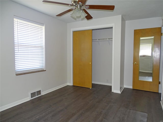 unfurnished bedroom featuring a closet, baseboards, visible vents, and dark wood-style flooring