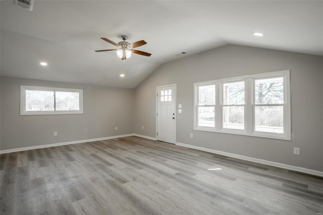 interior space with lofted ceiling, plenty of natural light, visible vents, and wood finished floors