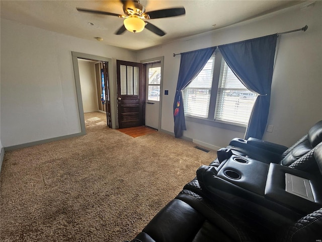 interior space with baseboards, carpet flooring, visible vents, and a ceiling fan