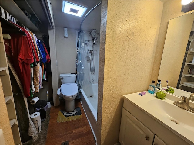 bathroom featuring a textured wall, vanity, toilet, and wood finished floors