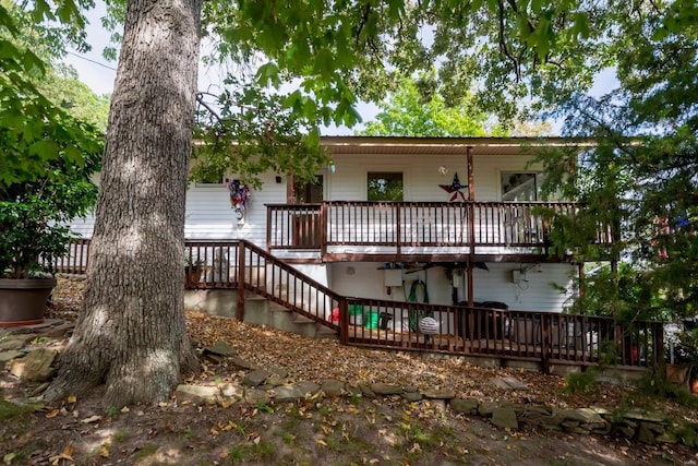 rear view of house featuring a wooden deck and stairs