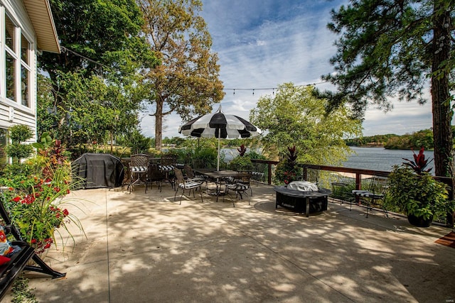 view of patio / terrace with a water view, a grill, and outdoor dining space