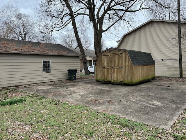 view of side of home with an outdoor structure, fence, and a shed