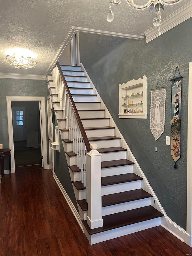 stairs featuring a textured wall, crown molding, and wood finished floors