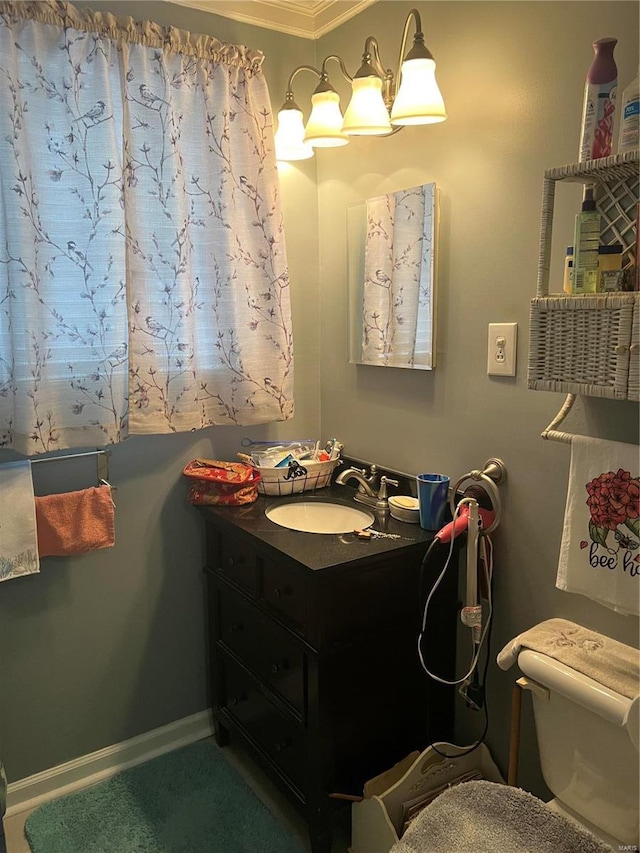 half bathroom with vanity, toilet, and baseboards