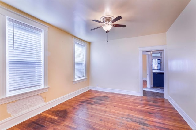 spare room with a ceiling fan, baseboards, and wood finished floors