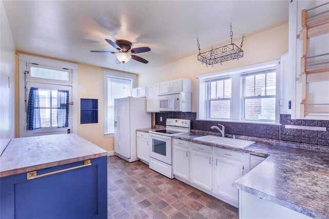 kitchen with a ceiling fan, a sink, backsplash, white cabinetry, and white appliances