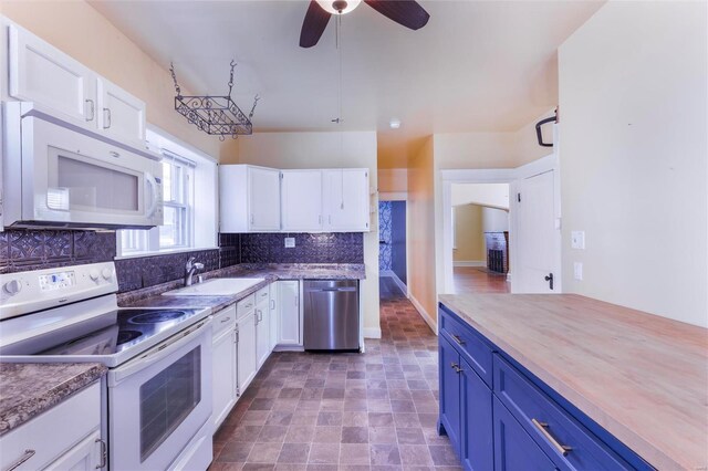 kitchen with blue cabinets, a sink, white cabinetry, white appliances, and decorative backsplash