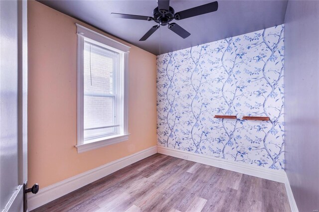 unfurnished room featuring a ceiling fan, baseboards, and wood finished floors