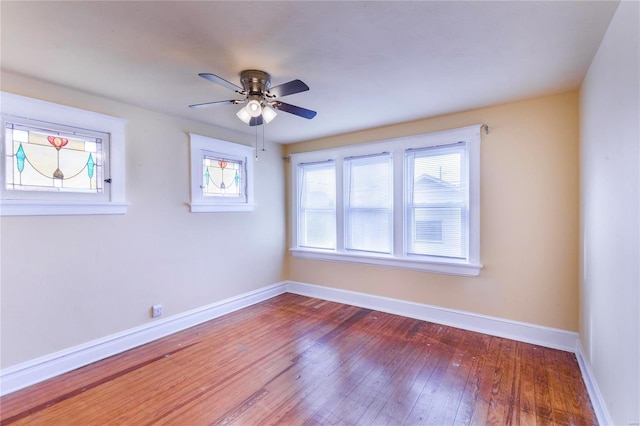 spare room featuring baseboards, wood-type flooring, and ceiling fan