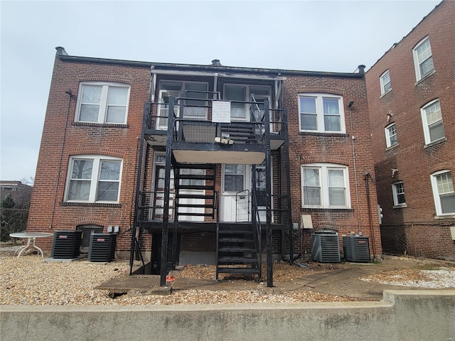 townhome / multi-family property with cooling unit and brick siding