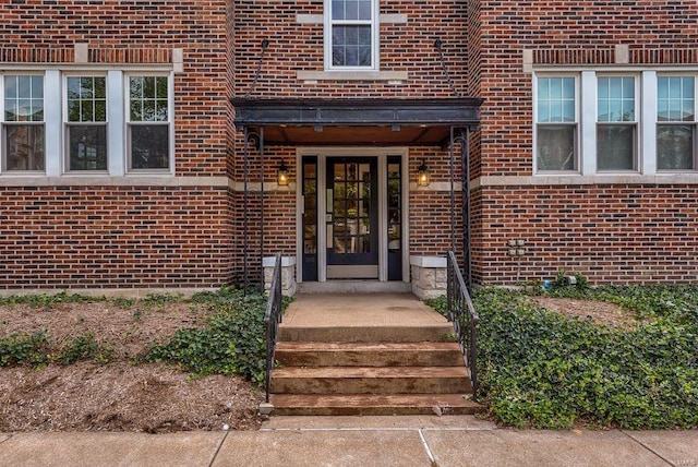 view of exterior entry with brick siding