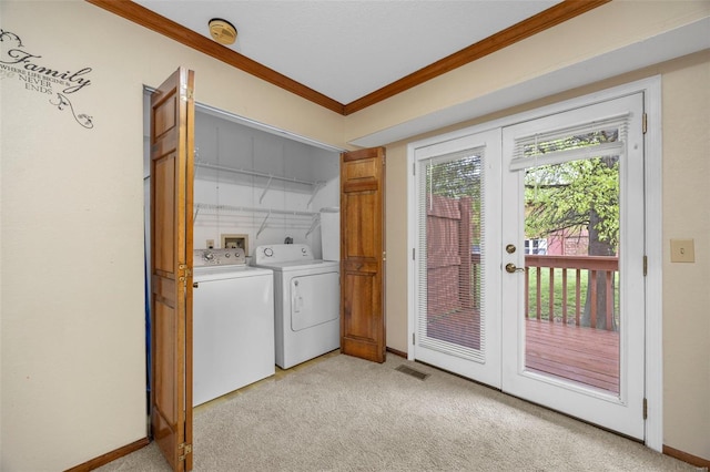 washroom with laundry area, crown molding, washing machine and dryer, light carpet, and baseboards