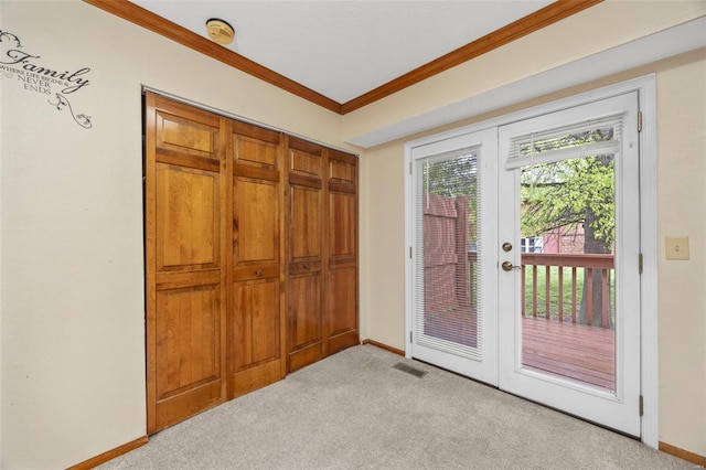 doorway to outside featuring baseboards, ornamental molding, visible vents, and light colored carpet
