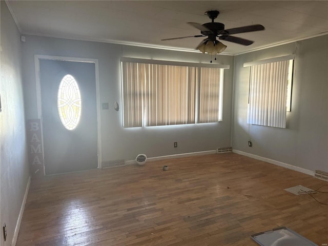 foyer entrance with a healthy amount of sunlight, wood-type flooring, and ornamental molding