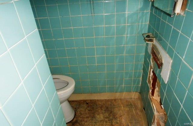 bathroom featuring toilet, tile walls, and tile patterned floors