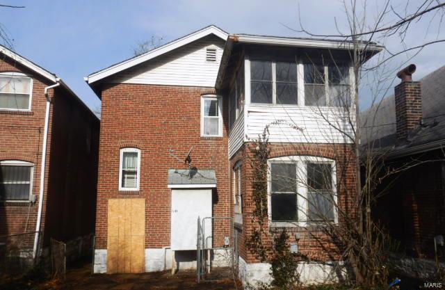 rear view of house with brick siding and a sunroom