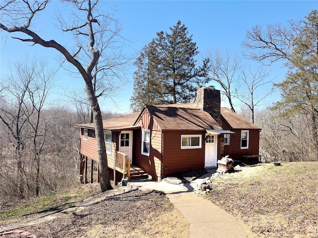 view of front of house featuring cooling unit and a chimney