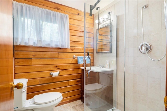 bathroom featuring toilet, wood walls, a shower stall, and tile patterned flooring