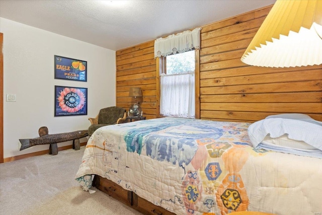 bedroom with wooden walls, a textured ceiling, and carpet