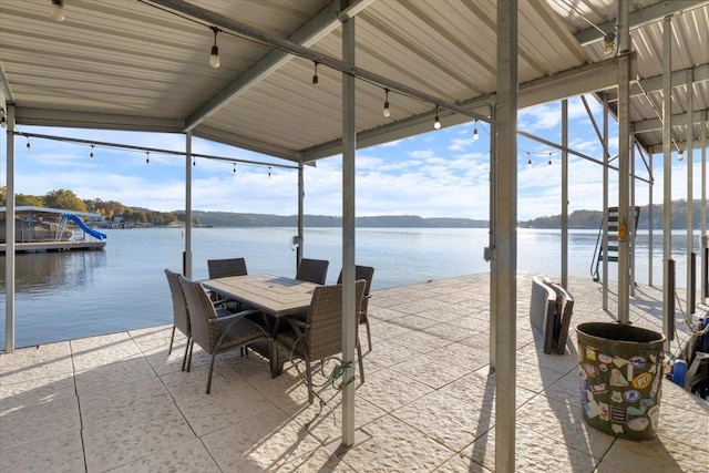 dock area with outdoor dining area, a water view, and a patio