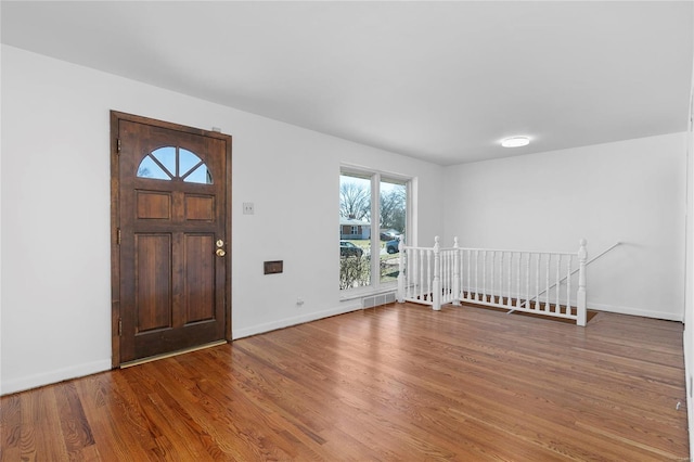 foyer entrance with visible vents, baseboards, and wood finished floors