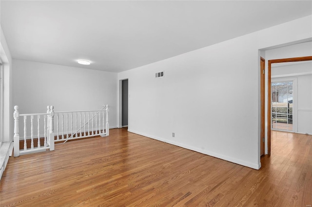 unfurnished room with light wood-style flooring, visible vents, and baseboards