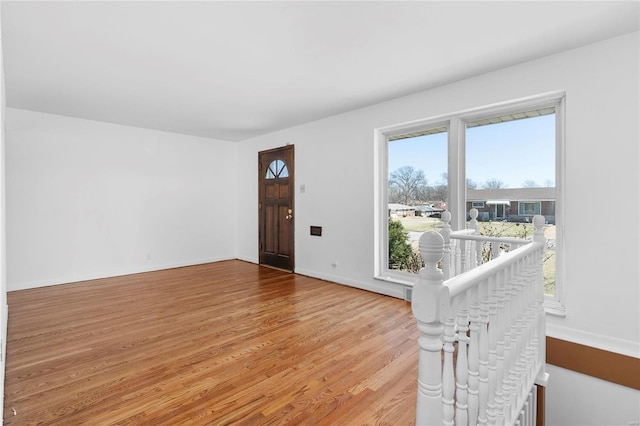 foyer featuring baseboards and wood finished floors