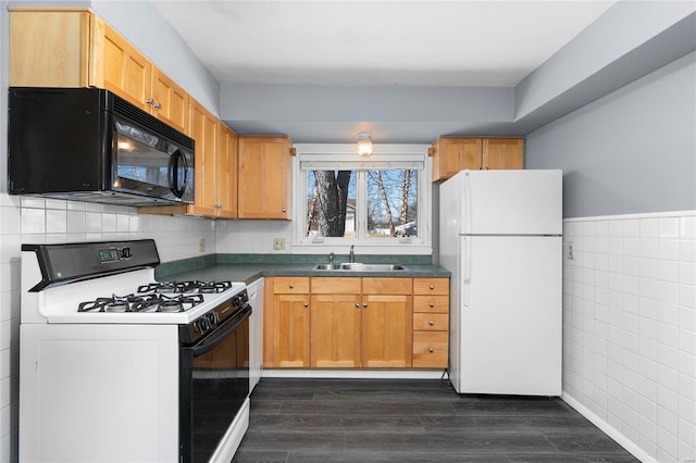 kitchen featuring black microwave, dark wood-style flooring, a sink, freestanding refrigerator, and gas range oven