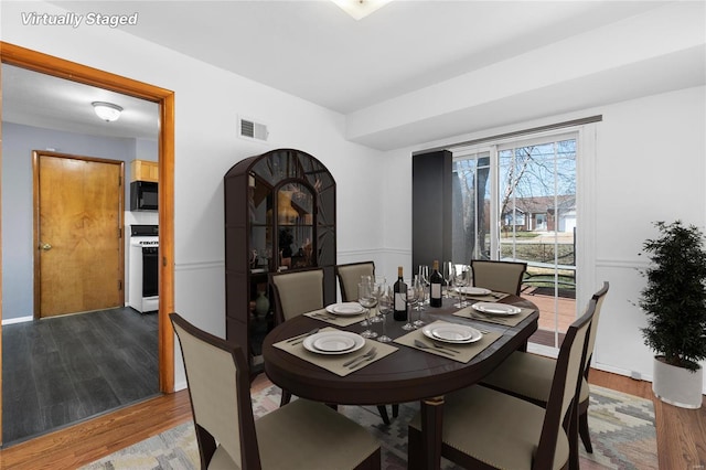 dining space with visible vents and wood finished floors