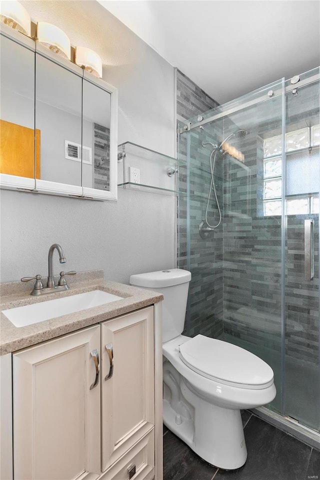 bathroom featuring vanity, toilet, and a shower stall