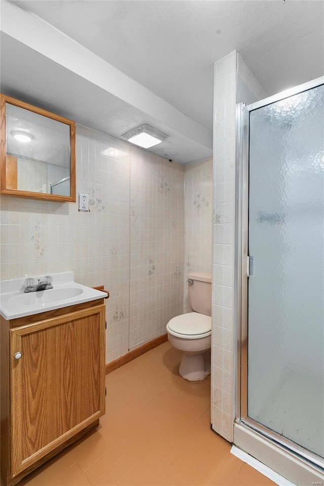 bathroom with toilet, a shower stall, and vanity