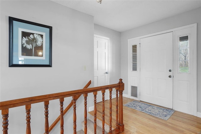 foyer entrance featuring baseboards and light wood finished floors