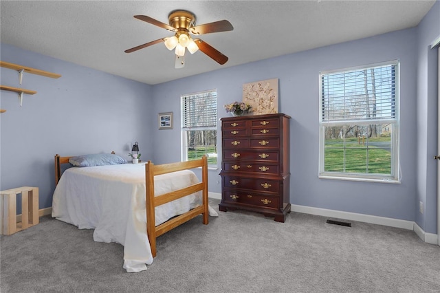 bedroom with carpet flooring, baseboards, visible vents, and ceiling fan