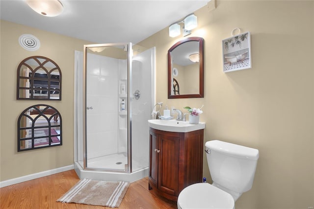 full bath with wood finished floors, toilet, a stall shower, and vanity