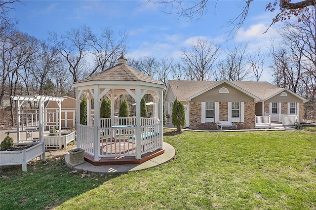 exterior space featuring a gazebo, a yard, brick siding, and a garden