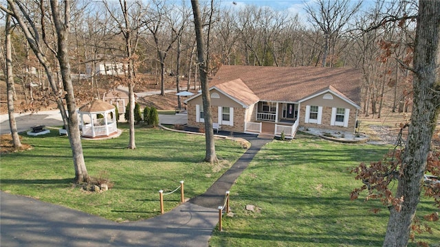 view of front facade with a porch, brick siding, and a front yard