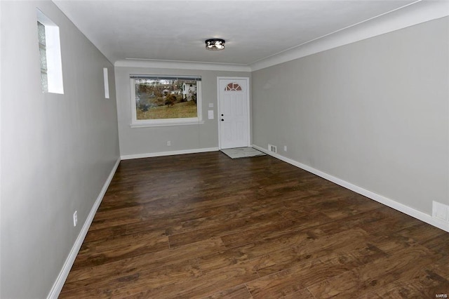 unfurnished room with visible vents, baseboards, and dark wood-style flooring