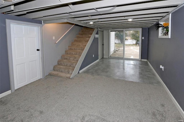 below grade area featuring stairs, carpet, and baseboards