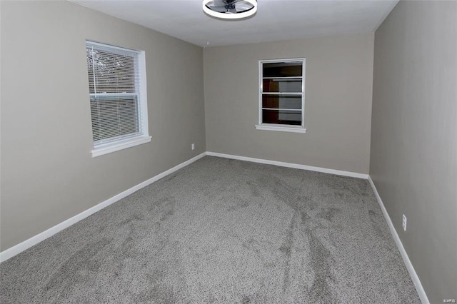 unfurnished room featuring carpet floors and baseboards