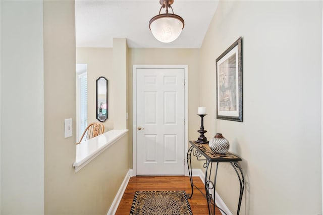 doorway to outside with baseboards and wood finished floors