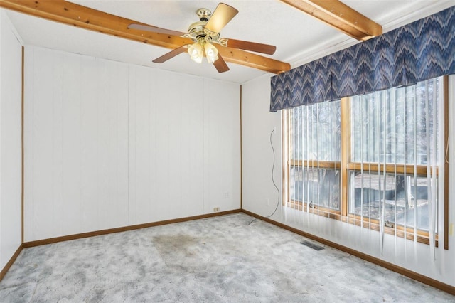 unfurnished room featuring beamed ceiling, carpet floors, visible vents, and a ceiling fan