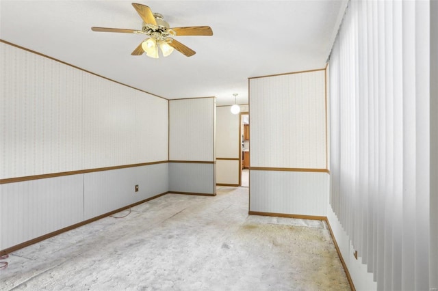 carpeted spare room with a ceiling fan and wallpapered walls