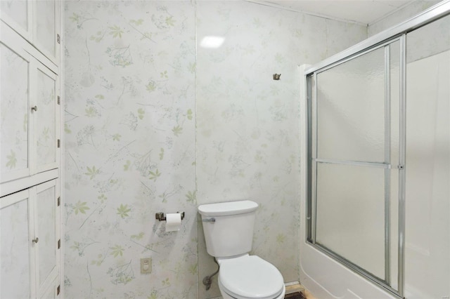 full bathroom featuring toilet, shower / bath combination with glass door, and wallpapered walls