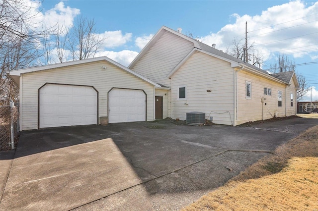 view of home's exterior with central air condition unit, an attached garage, and driveway